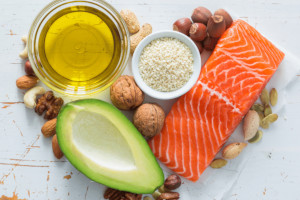 Salmon fillet, half and avocado and walnuts nuts on a marble slab