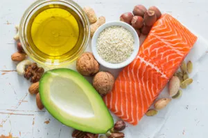 Salmon fillet, half and avocado and walnuts nuts on a marble slab